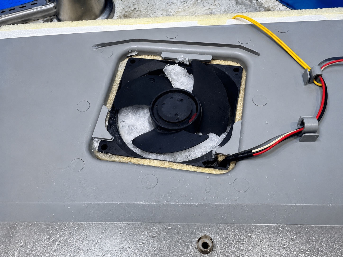 An evaporator fan packed solid with ice, unable to move cold air between the compartments