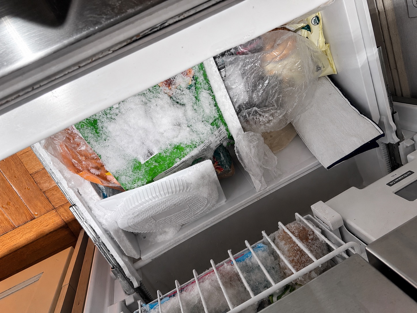 Food in a freezer drawer buried under heavy frost