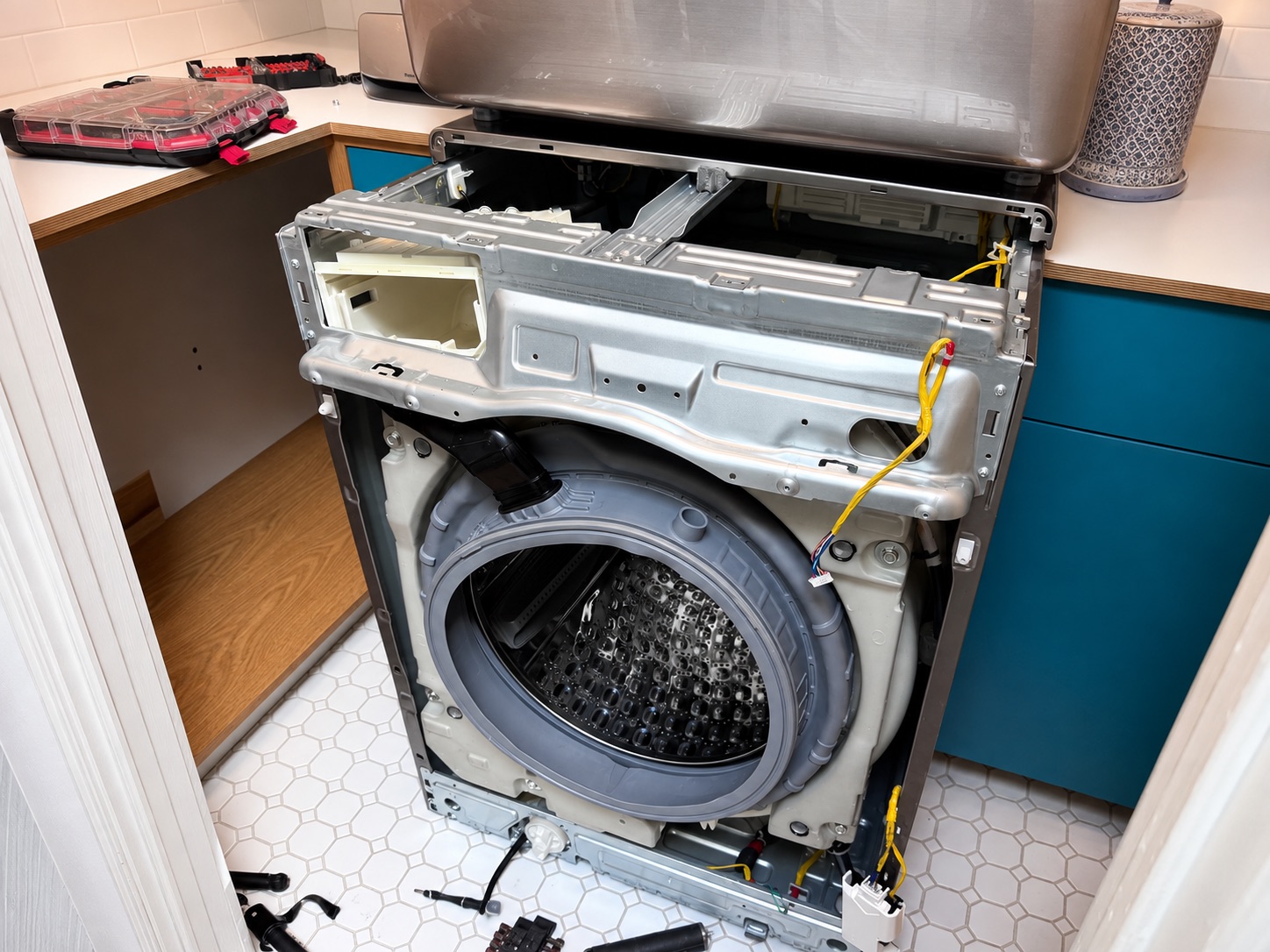 A washing machine with the front panel removed, exposing the drum and its suspension